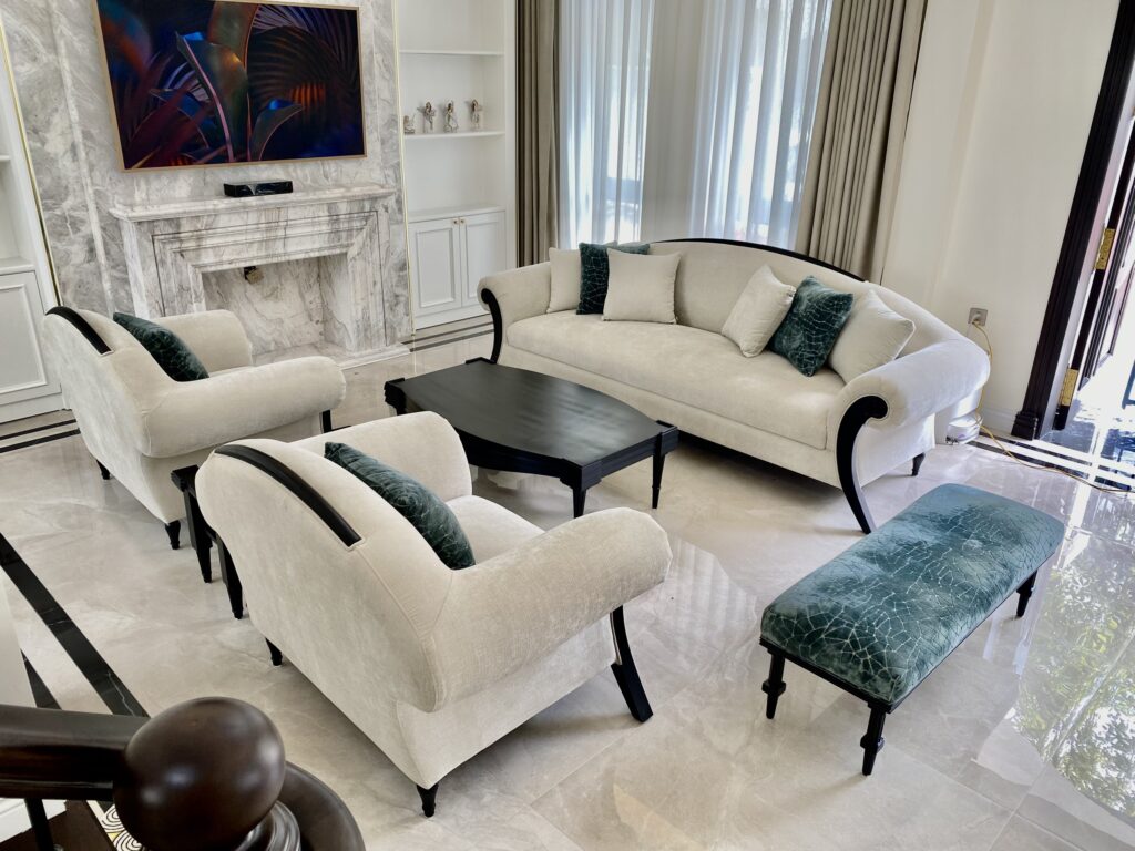 Hai armchair Adaline tân cổ điển bọc vải kem, tay vịn cuộn sơn đen, đặt đối diện sofa Adaline trong phòng khách biệt thự ốp đá