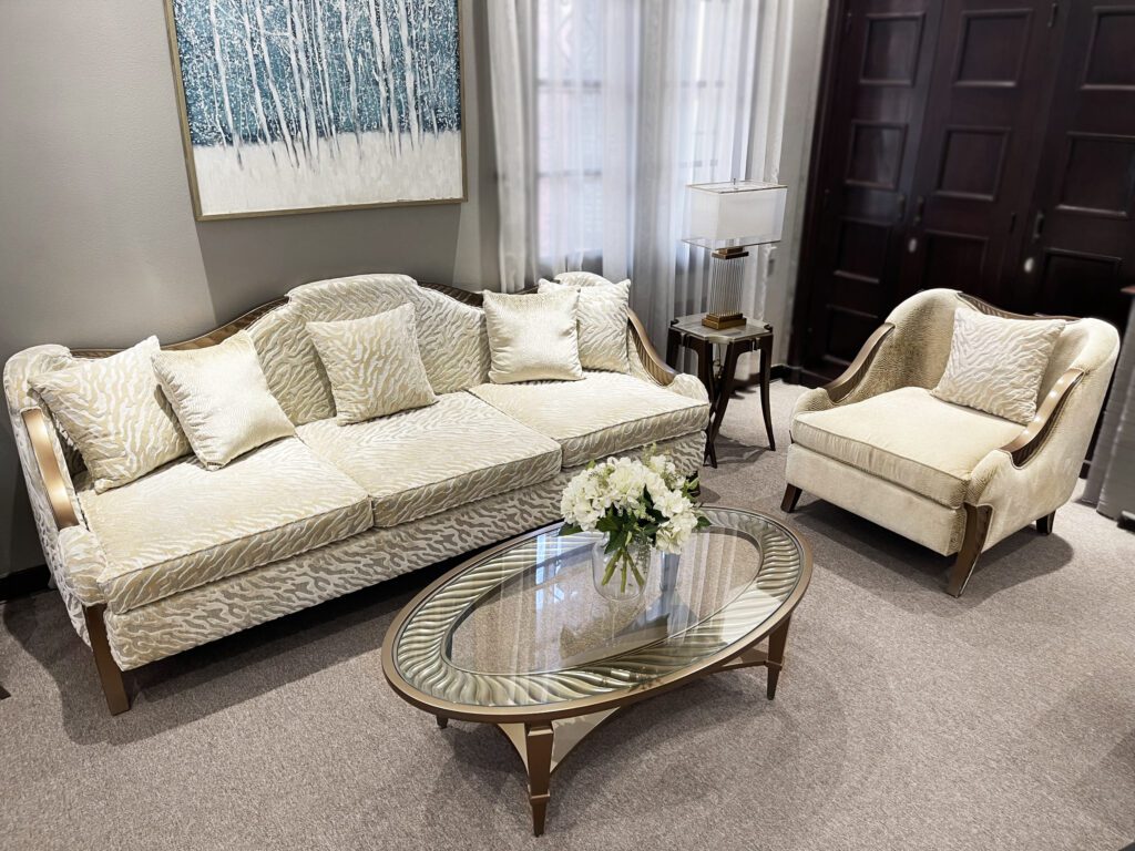 Bàn trà Il Finale tân cổ điển mặt kính oval viền gỗ ánh kim, trước sofa và ghế đơn màu kem